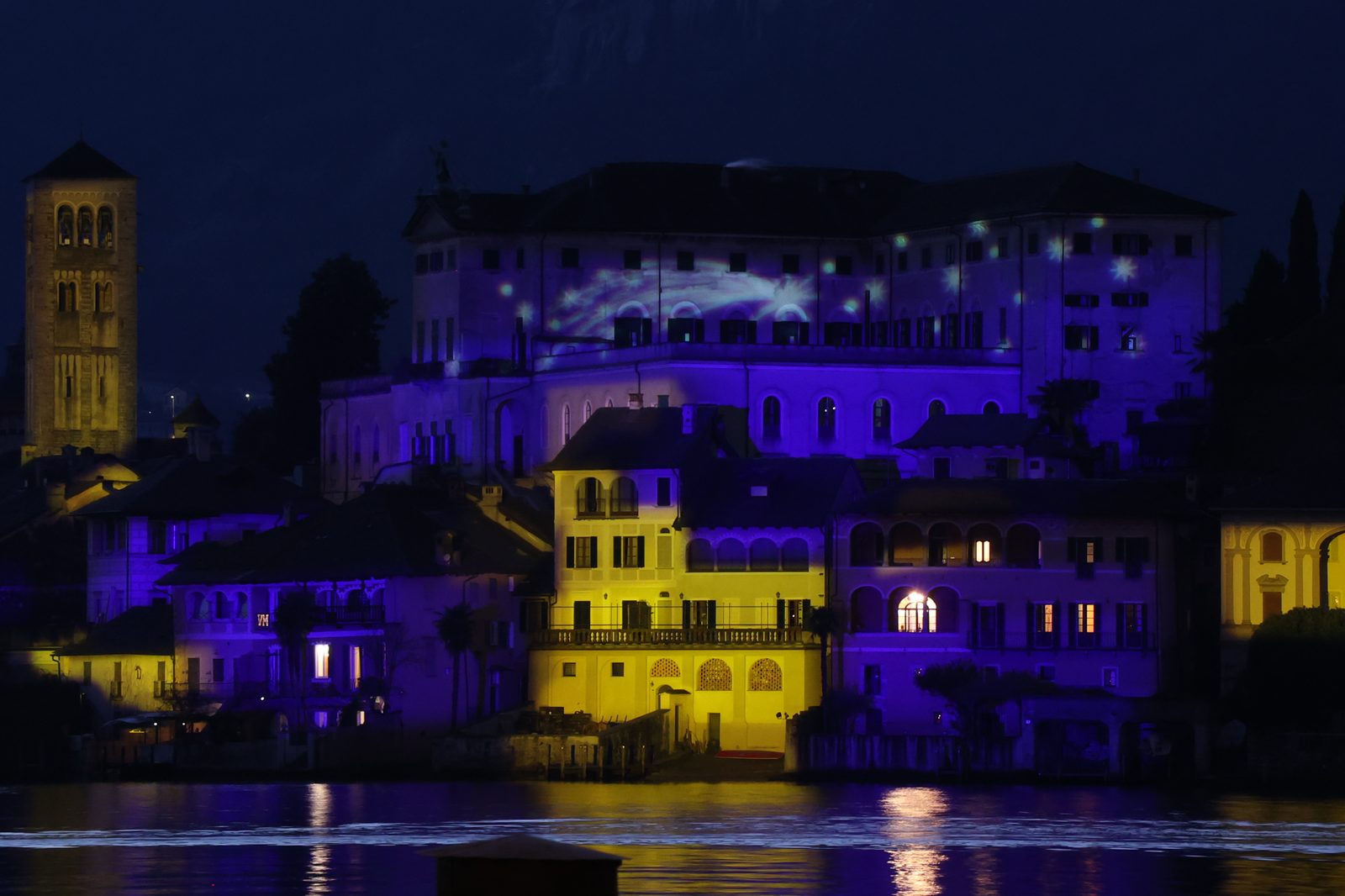L'Isola San Giulio di notte, con la basilica e il monastero illuminati di viola e oro per il Natale
