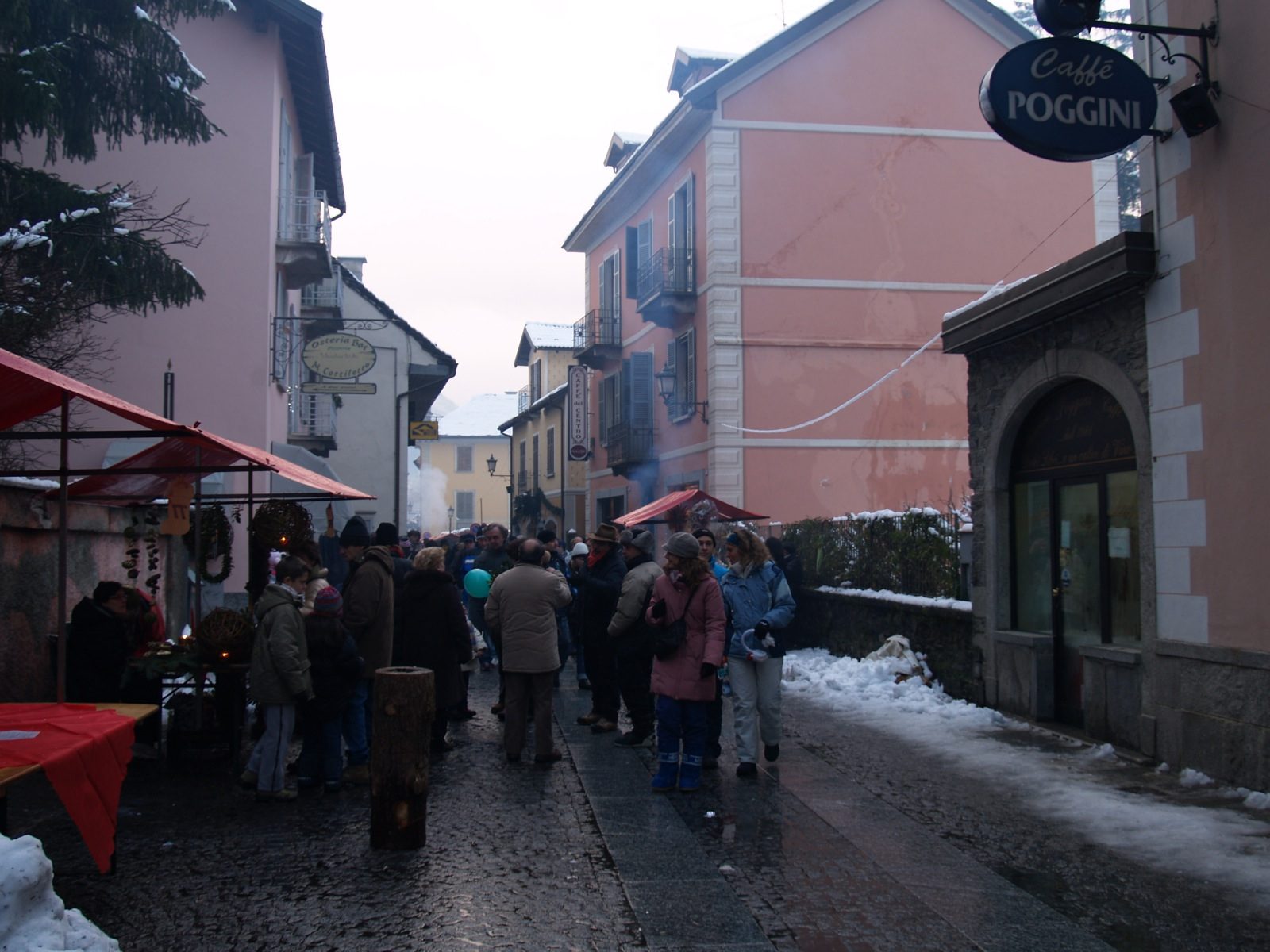 Bancarelle del mercatino di Natale lungo una via di Santa Maria Maggiore, con la neve ai bordi della strada