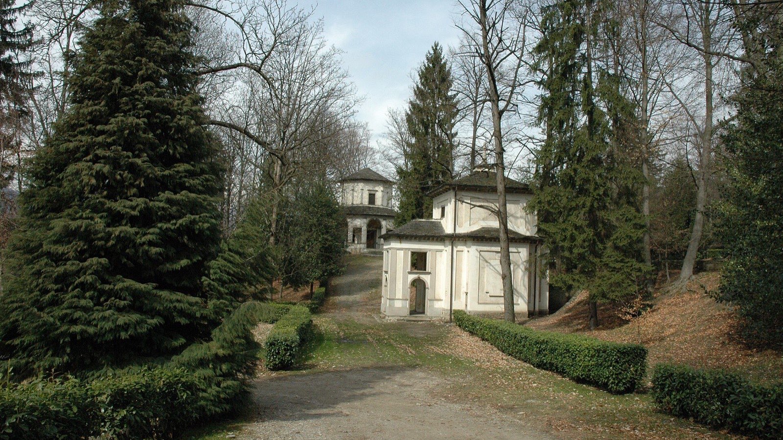 L'allée de gravier entre deux chapelles du Sacro Monte d'Orta, entourée de grands arbres