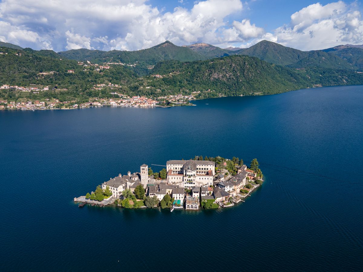 L’île San Giulio vue du ciel, avec la rive ouest et les montagnes derrière.
