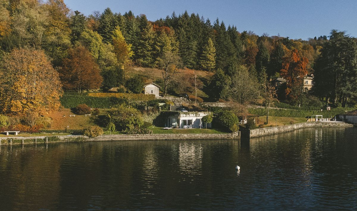 The east shore in autumn, with Villa Volpe at the water&rsquo;s edge.
