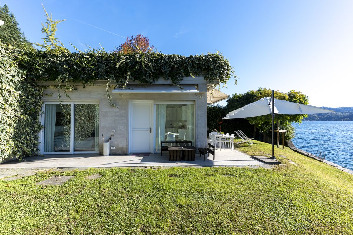 The glass façade, the garden and the parasol by the lake
