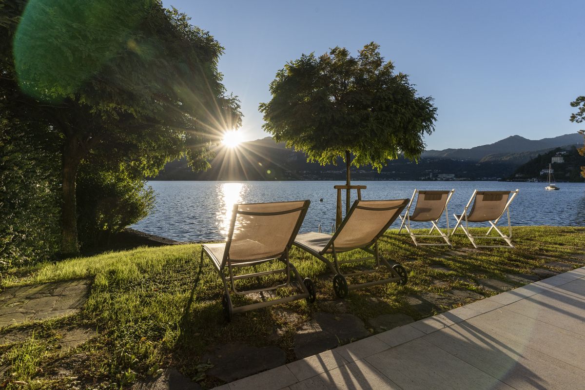 Sun loungers on the lawn at sunset, the light reflected on the lake